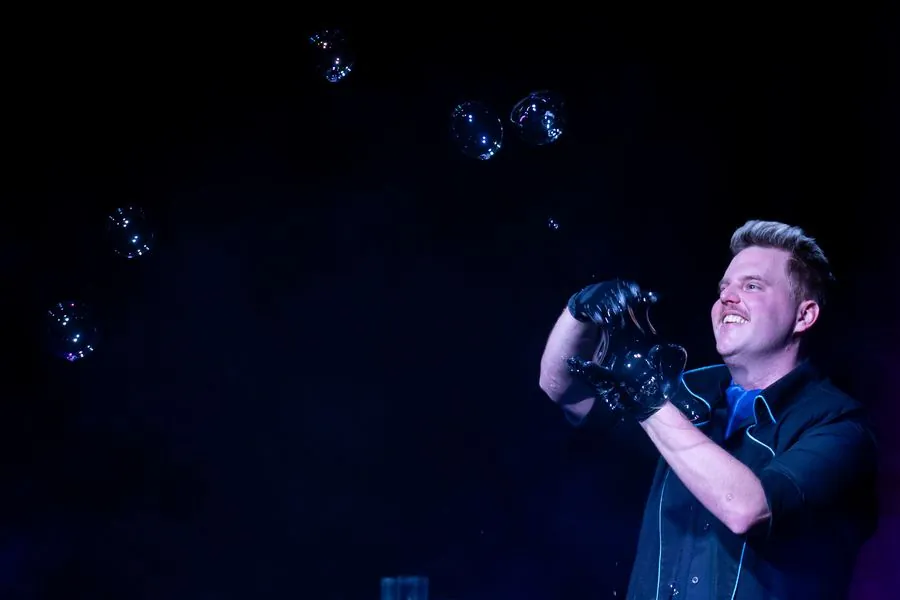 Marton Crystal smiling at small bubbles in blue light